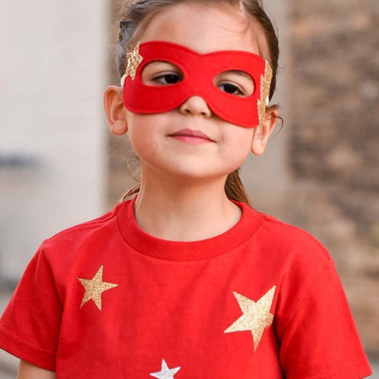 a little girl with a red mask and stars on her face