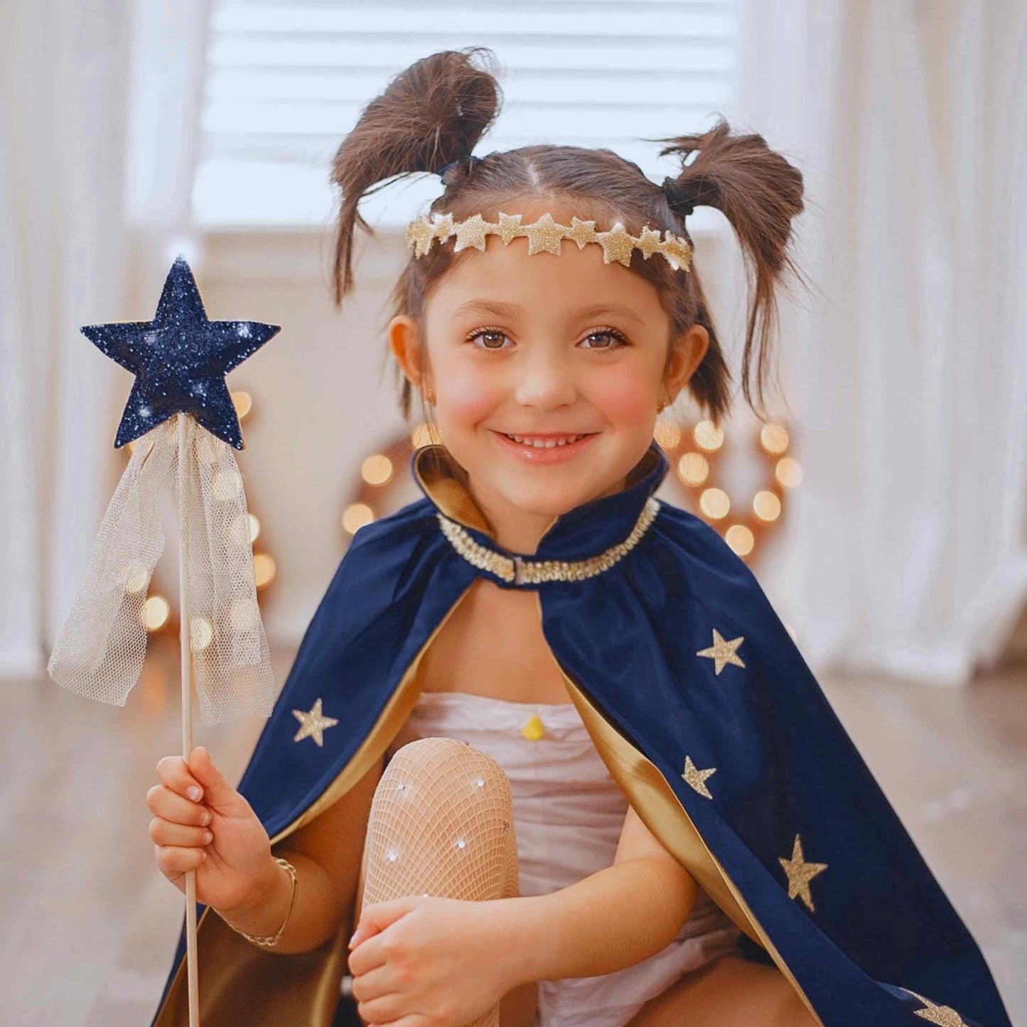 a little girl dressed as a princess holding a wand