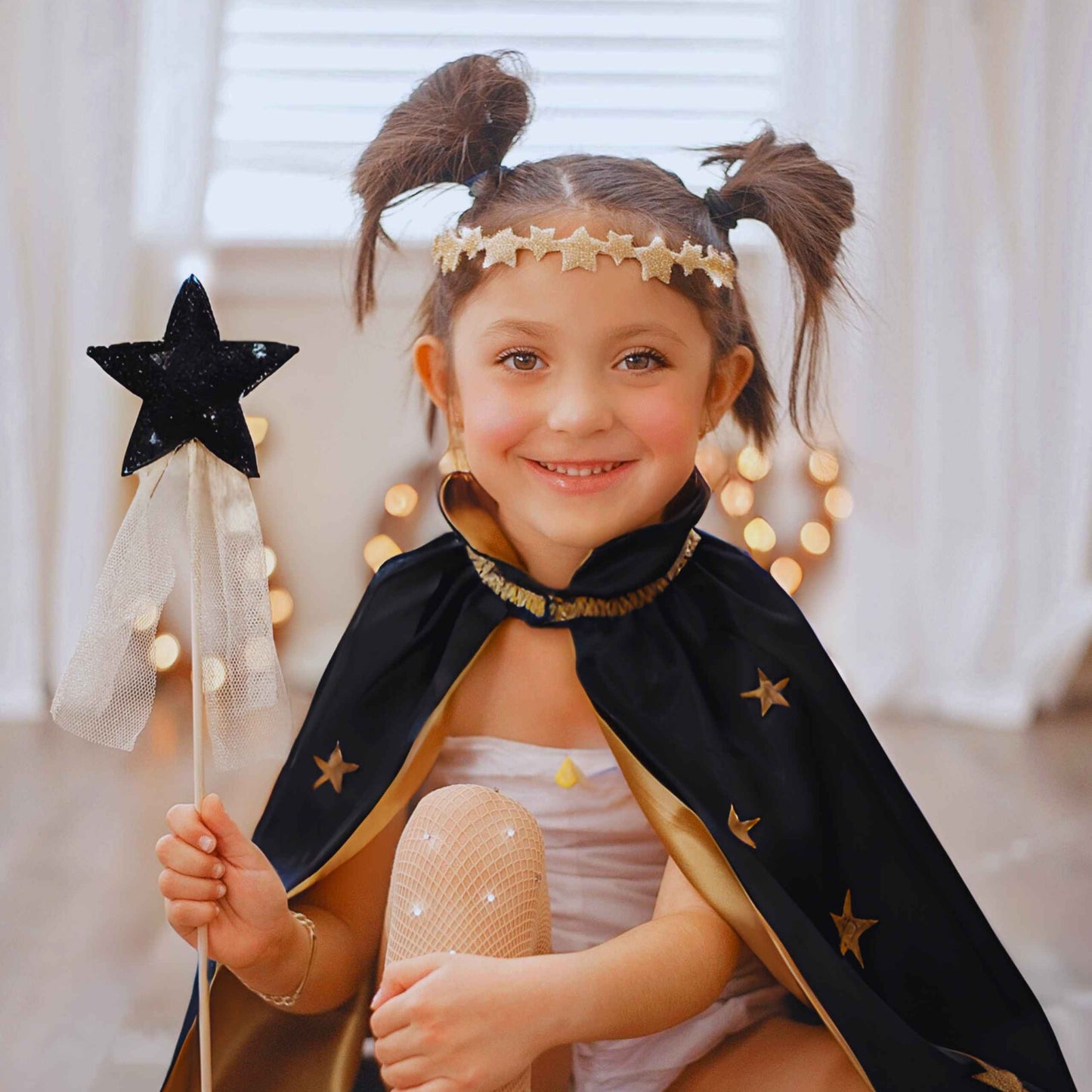 a little girl dressed as a princess holding a wand