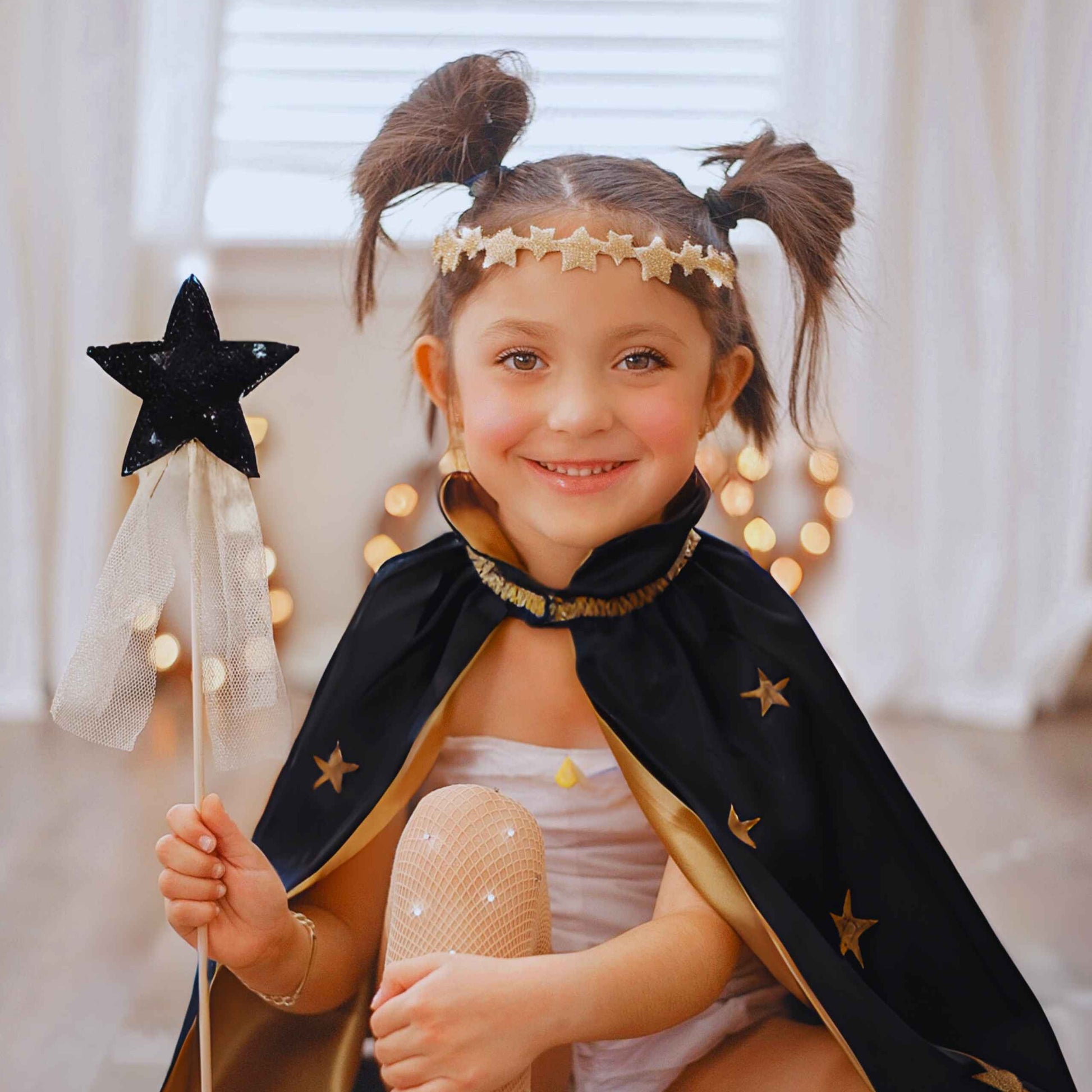 a little girl dressed as a princess holding a wand