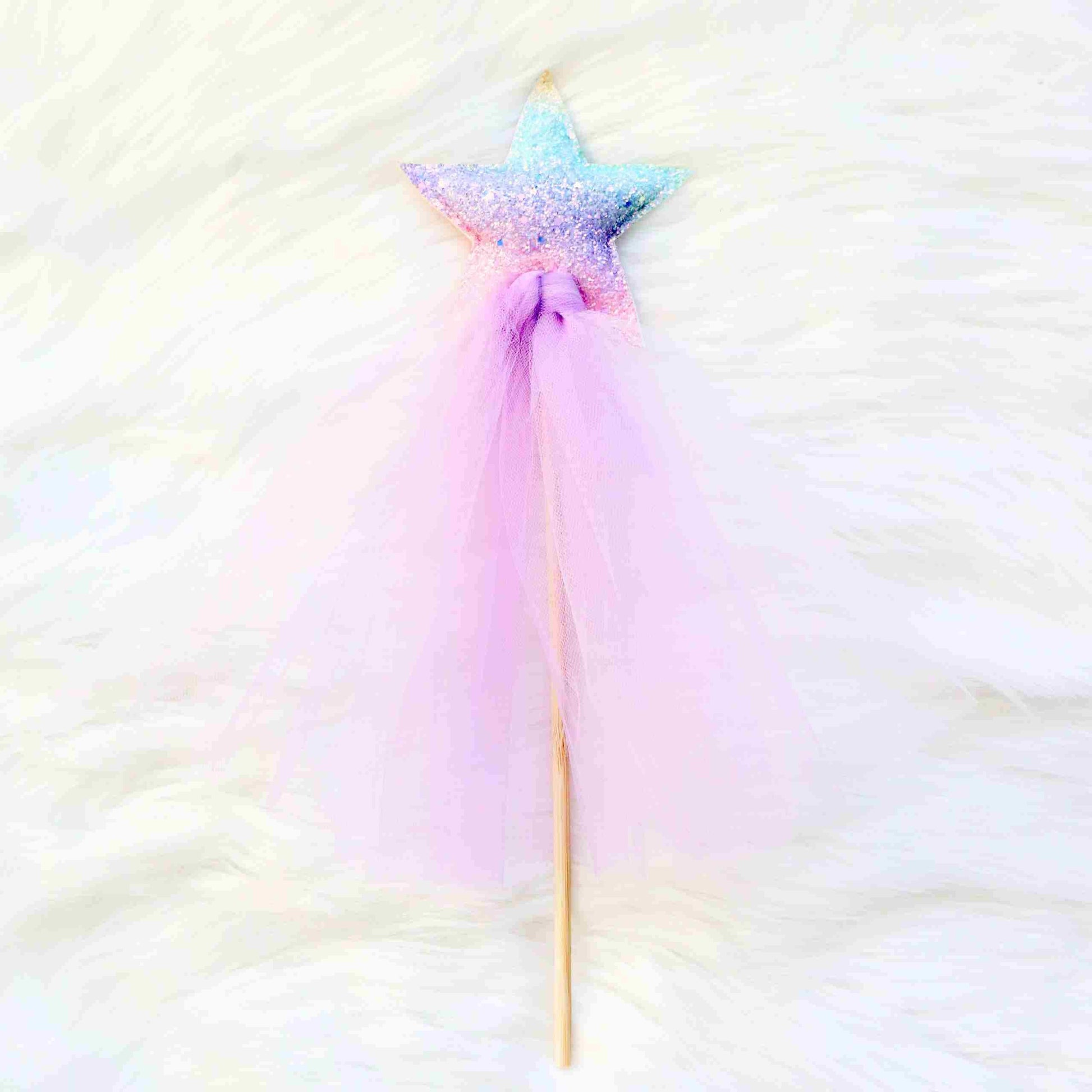 a pink and blue star shaped wand on a white background
