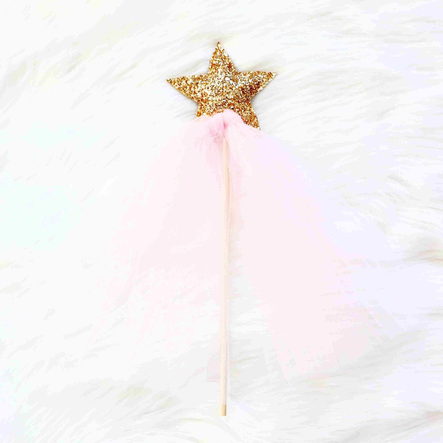 a pink and gold star wand on a white background